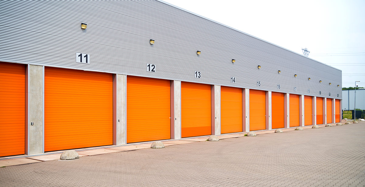 exterior of a commercial warehouse with orange roller doors